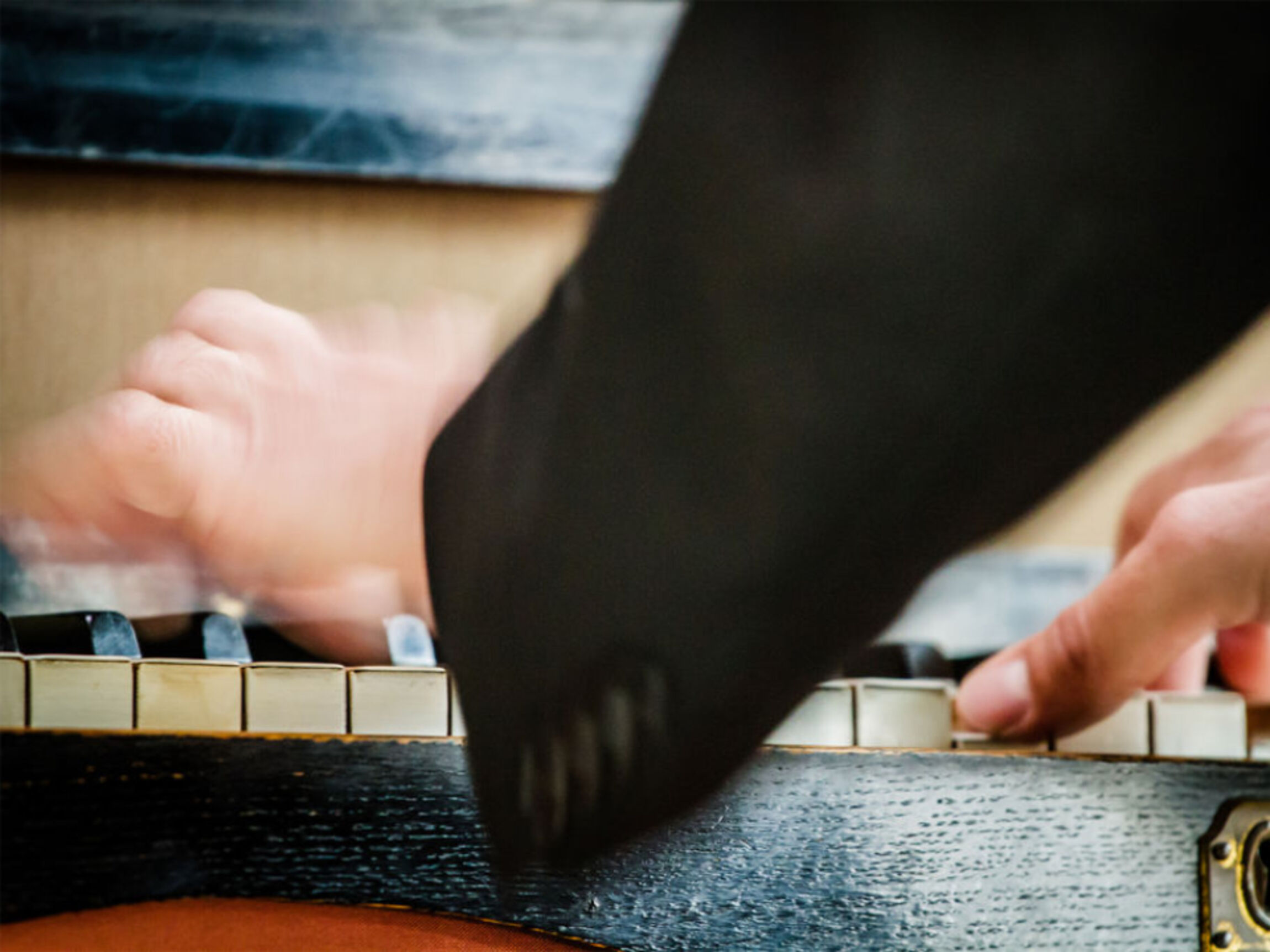 Hände bewegen sich über einer Orgeltastatur.