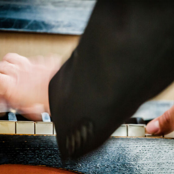Hände bewegen sich über einer Orgeltastatur.